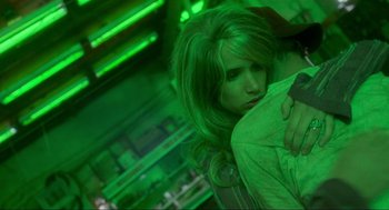 Movie still from “Natural Born Killers” (1994), directed by Oliver Stone – A woman is holding a pillow in a green room; Close Up shot, Low angle