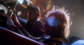 Movie still from “Natural Born Killers” (1994), directed by Oliver Stone – Two people sitting in a car in the dark; Close Up shot, Low angle