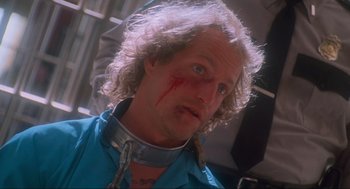 Movie still from “Natural Born Killers” (1994), directed by Oliver Stone – A person wearing a neck brace; Close Up shot, Low angle