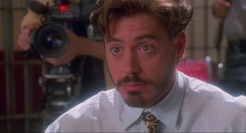 Movie still from “Natural Born Killers” (1994), directed by Oliver Stone – A person wearing a shirt and a tie; Close Up shot, Over the shoulder angle