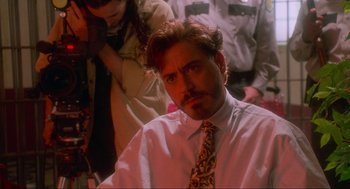 Movie still from “Natural Born Killers” (1994), directed by Oliver Stone – A person wearing a shirt and a tie; Close Up shot, Over the shoulder angle