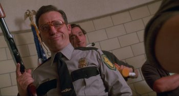 Movie still from “Natural Born Killers” (1994), directed by Oliver Stone – A man in a police uniform and a man in a suit and tie; Close Up shot, Low angle