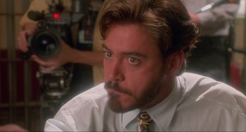 Movie still from “Natural Born Killers” (1994), directed by Oliver Stone – A person wearing a shirt and a tie; Close Up shot, Over the shoulder angle