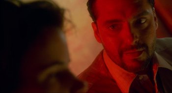 Movie still from “Natural Born Killers” (1994), directed by Oliver Stone – A person looking at a camera; Close Up shot, Over the shoulder angle