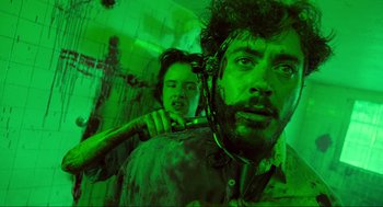 Movie still from “Natural Born Killers” (1994), directed by Oliver Stone – A man holding a pipe in his mouth while another man holds a bat in his other hand; Medium shot, Low angle