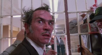Movie still from “Natural Born Killers” (1994), directed by Oliver Stone – A person wearing a suit and tie; Close Up shot, Low angle