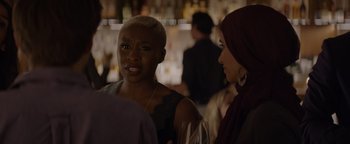 Movie still from “Needle in a Timestack” (2021), directed by John Ridley – Two women are standing in a bar talking to each other; Close Up shot, Over the shoulder angle