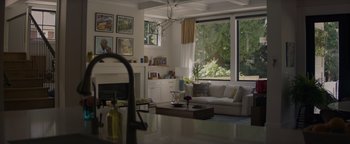 Movie still from “Needle in a Timestack” (2021), directed by John Ridley – A living room filled with furniture next to a fire place; Wide shot, Low angle
