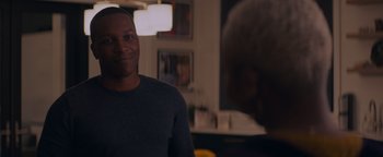 Movie still from “Needle in a Timestack” (2021), directed by John Ridley – A man standing in front of a mirror in a room; Medium shot, Over the shoulder angle