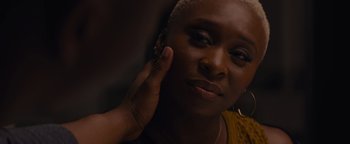 Movie still from “Needle in a Timestack” (2021), directed by John Ridley – A person touching their ear; Close Up shot, Over the shoulder angle