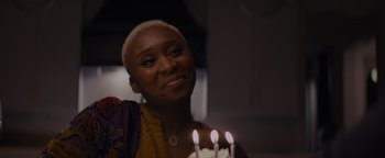 Movie still from “Needle in a Timestack” (2021), directed by John Ridley – A woman holding a cake with lit candles on it; Close Up shot, Over the shoulder angle