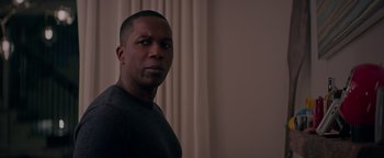 Movie still from “Needle in a Timestack” (2021), directed by John Ridley – A man standing in front of a wall with curtains; Close Up shot, Over the shoulder angle