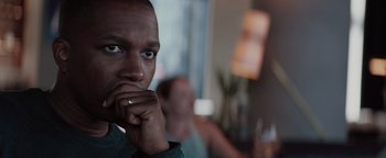 Movie still from “Needle in a Timestack” (2021), directed by John Ridley – A person with his hand under his chin; Close Up shot, Over the shoulder angle