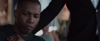 Movie still from “Needle in a Timestack” (2021), directed by John Ridley – A young man getting his hair cut by a stylist; Close Up shot, Over the shoulder angle