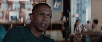 Movie still from “Needle in a Timestack” (2021), directed by John Ridley – A person wearing a green shirt; Close Up shot, Over the shoulder angle