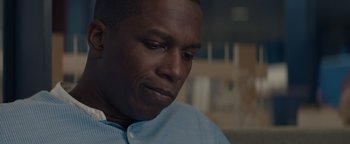 Movie still from “Needle in a Timestack” (2021), directed by John Ridley – A person sitting down; Close Up shot, Low angle