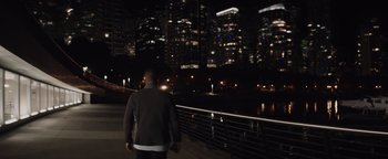 Movie still from “Needle in a Timestack” (2021), directed by John Ridley – A man standing on the side of a bridge at night; Wide shot, High angle