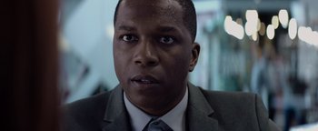 Movie still from “Needle in a Timestack” (2021), directed by John Ridley – A person wearing a suit and tie; Close Up shot, Over the shoulder angle