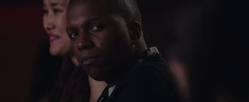 Movie still from “Needle in a Timestack” (2021), directed by John Ridley – A person wearing a suit and tie; Close Up shot, Over the shoulder angle