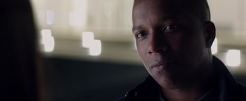 Movie still from “Needle in a Timestack” (2021), directed by John Ridley – A man's face in front of a blurry background; Close Up shot, Low angle
