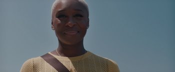Movie still from “Needle in a Timestack” (2021), directed by John Ridley – A person smiling for the camera; Close Up shot, Low angle