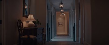 Movie still from “Needle in a Timestack” (2021), directed by John Ridley – A hallway with a lamp and a table in it; Wide shot, Low angle