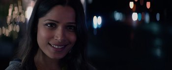 Movie still from “Needle in a Timestack” (2021), directed by John Ridley – A woman smiling for the camera; Close Up shot, Over the shoulder angle