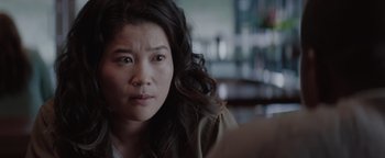 Movie still from “Needle in a Timestack” (2021), directed by John Ridley – A person sitting in a room; Close Up shot, Over the shoulder angle