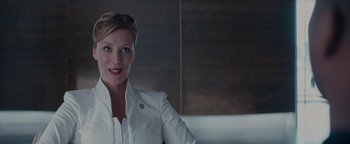 Movie still from “Needle in a Timestack” (2021), directed by John Ridley – A woman in a white jacket smiling for the camera; Close Up shot, Low angle