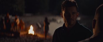 Movie still from “Needle in a Timestack” (2021), directed by John Ridley – A man standing in front of a fire at night; Close Up shot, Over the shoulder angle