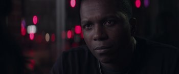 Movie still from “Needle in a Timestack” (2021), directed by John Ridley – A person wearing a black shirt; Close Up shot, Over the shoulder angle