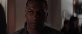 Movie still from “Needle in a Timestack” (2021), directed by John Ridley – A man's face in a dark room; Close Up shot, Over the shoulder angle