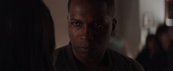 Movie still from “Needle in a Timestack” (2021), directed by John Ridley – A person's face in a dark room; Close Up shot, Over the shoulder angle