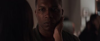 Movie still from “Needle in a Timestack” (2021), directed by John Ridley – A person with his hand under his chin; Close Up shot, Over the shoulder angle