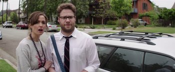 Movie still from “Neighbors” (2014), directed by Nicholas Stoller – A man standing next to a car in a parking lot; Medium shot, Over the shoulder angle