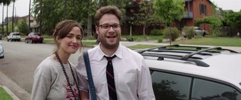 Movie still from “Neighbors” (2014), directed by Nicholas Stoller – A man and a woman standing next to each other in front of a car; Medium shot, Over the shoulder angle