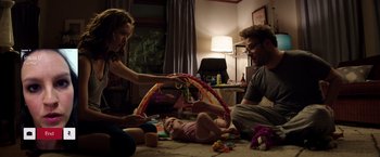 Movie still from “Neighbors” (2014), directed by Nicholas Stoller – A man and a woman playing with a baby in a living room; Medium shot, Over the shoulder angle