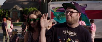 Movie still from “Neighbors” (2014), directed by Nicholas Stoller – A man and a woman wave at the crowd; Medium shot, Over the shoulder angle