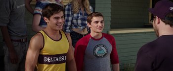 Movie still from “Neighbors” (2014), directed by Nicholas Stoller – Two young men standing next to each other in front of a building; Medium shot, Over the shoulder angle