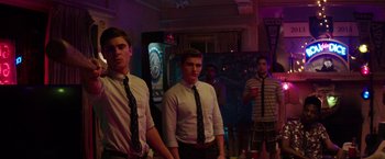 Movie still from “Neighbors” (2014), directed by Nicholas Stoller – A group of young men standing next to each other in a room; Medium shot, Over the shoulder angle