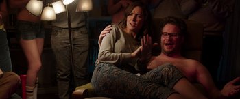 Movie still from “Neighbors” (2014), directed by Nicholas Stoller – A man and a woman sitting on a couch together; Medium shot, Over the shoulder angle