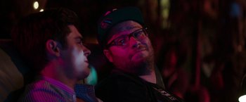 Movie still from “Neighbors” (2014), directed by Nicholas Stoller – A man with a beard wearing glasses and a hat; Close Up shot, Over the shoulder angle