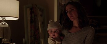 Movie still from “Neighbors” (2014), directed by Nicholas Stoller – A woman holding a baby in her arms and wearing a hat; Close Up shot, Over the shoulder angle