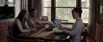 Movie still from “Neighbors” (2014), directed by Nicholas Stoller – Three people sitting at a table talking to each other; Medium shot, Over the shoulder angle