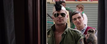 Movie still from “Neighbors” (2014), directed by Nicholas Stoller – A man wearing a hat and sunglasses with a mohawk; Close Up shot, Over the shoulder angle