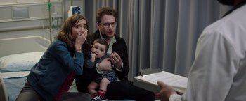 Movie still from “Neighbors” (2014), directed by Nicholas Stoller – A man and woman holding a baby in front of another man; Medium shot, Over the shoulder angle