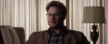 Movie still from “Neighbors” (2014), directed by Nicholas Stoller – A person wearing glasses and a jacket; Close Up shot, Over the shoulder angle