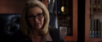 Movie still from “Neighbors” (2014), directed by Nicholas Stoller – A woman wearing glasses sitting in an office chair; Close Up shot, Over the shoulder angle