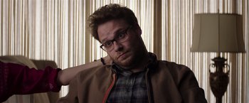 Movie still from “Neighbors” (2014), directed by Nicholas Stoller – A person wearing glasses and a jacket; Close Up shot, Over the shoulder angle