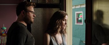 Movie still from “Neighbors” (2014), directed by Nicholas Stoller – A man and a woman standing next to each other near a wall; Close Up shot, Over the shoulder angle